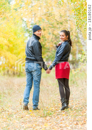 Young romantic couple walks in autumn forest 18180162