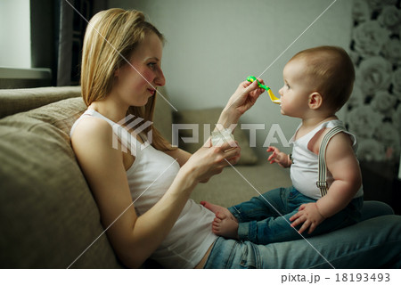 mother feeding baby with a spoon mother feeding baby with a spoon 18193493