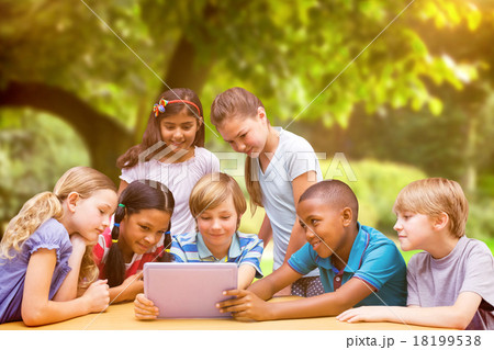 Composite image of cute pupils using tablet computer in library Composite image of cute pupils using tablet computer in library 18199538