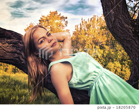 Young sensual blonde girl lying on a tree branch Young sensual blonde girl lying on a tree branch 18205870