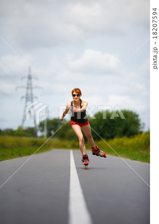 Attractive girl rollerblading on the road Attractive girl rollerblading on the road 18207594