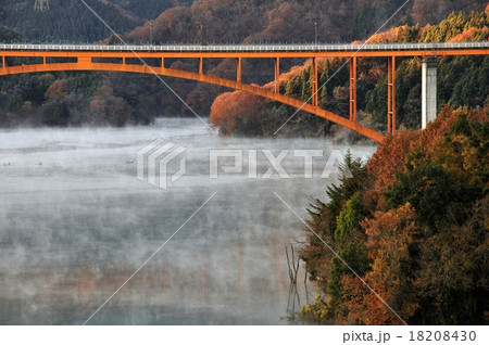 宮ヶ瀬湖の川霧と紅葉と虹の大橋の写真素材