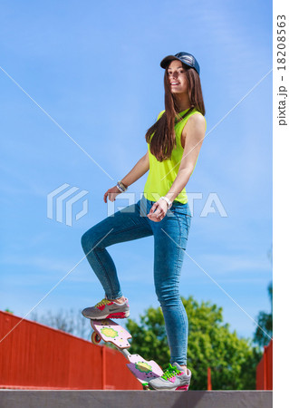 Teen girl skater riding skateboard on street. 18208563