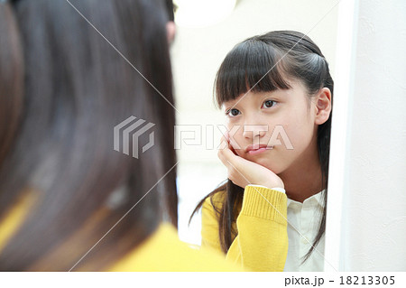 鏡を見つめて悩む中学生女子 18213305
