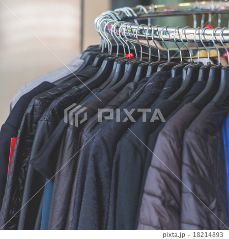Dark autumn clothes hanging at a store Dark autumn clothes hanging at a store 18214893