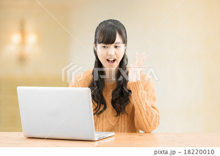 セータを着てシンプルな室内に座っているロングヘアーの10代の女性 18220010