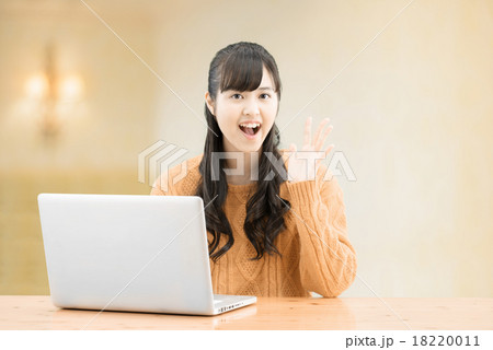 セータを着てシンプルな室内に座っているロングヘアーの10代の女性 18220011