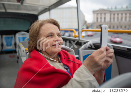 Pensioner woman taking photos by phone in touristi 18228570