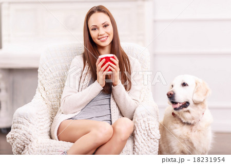 Pretty girl in the armchair with her pet around. Pretty girl in the armchair with her pet around. 18231954