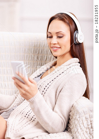 Young girl in the armchair listening to music. Young girl in the armchair listening to music. 18231955