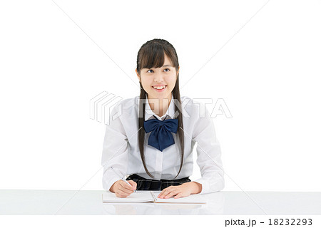 座っている制服姿の女子学生の白バックのポーズの写真素材