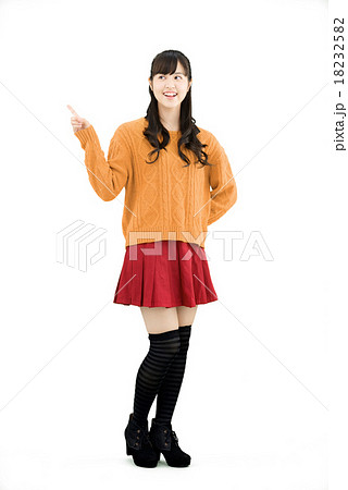 セーターを着て立っている若い女性の全身の白バックポーズ 18232582