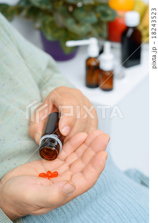 Old man takes out a few pills of remedy. 18243523