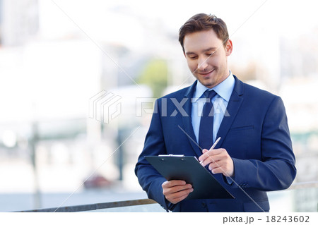 Gentleman in suit using a clipboard. 18243602