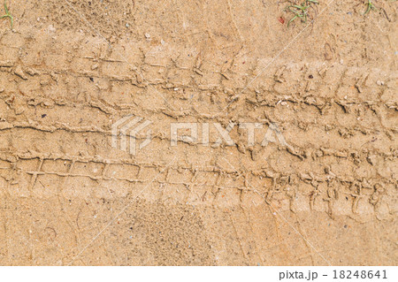 Tire tracks on dry brown yellow dirt road 18248641