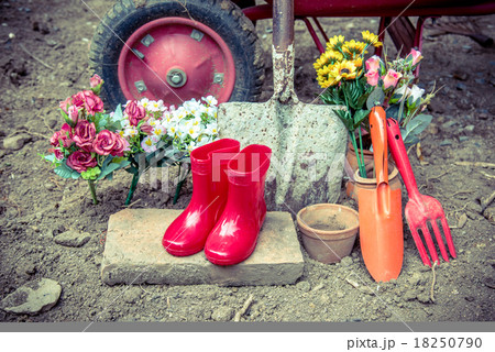 gardening tool including by red boots vase , fork , shovel and b 18250790