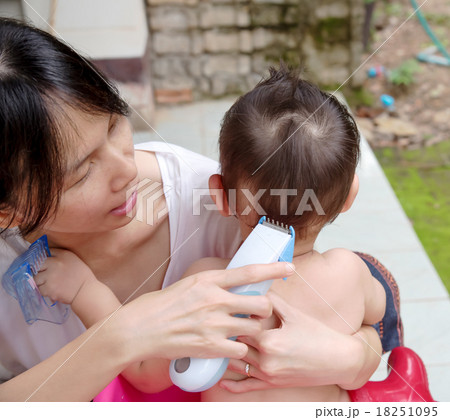 Mother cutting baby hair by hair clipper Mother cutting baby hair by hair clipper 18251095