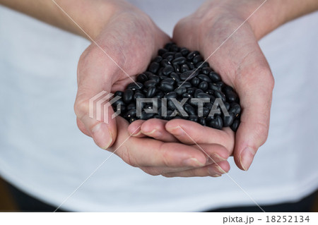 Woman showing handful of black beans 18252134