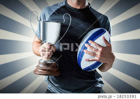 Composite image of midsection of successful rugby player holding 18253391