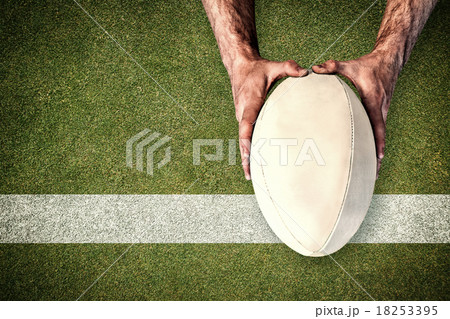 Composite image of man holding rugby ball Composite image of man holding rugby ball 18253395