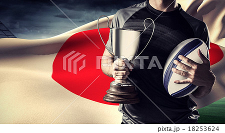 Composite image of midsection of successful rugby player holding Composite image of midsection of successful rugby player holding 18253624