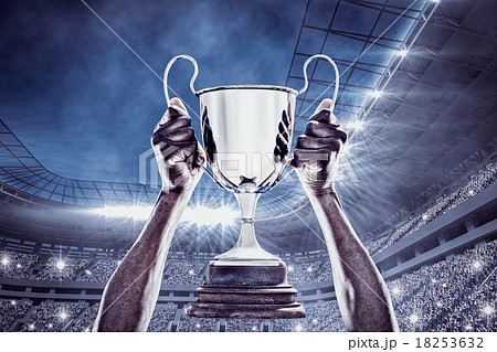 Composite image of cropped hand of athlete holding trophy 18253632