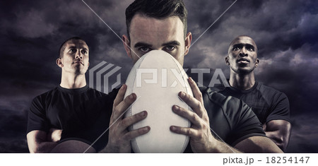 Composite image of tough rugby player holding ball 18254147