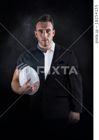 Composite image of tough rugby player holding ball 18254155