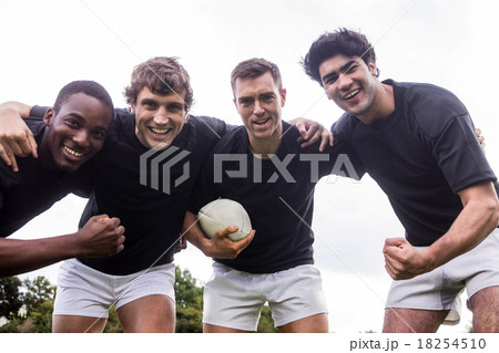 Rugby players cheering together with ball 18254510