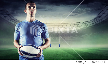 Composite image of confident rugby player holding ball Composite image of confident rugby player holding ball 18255064