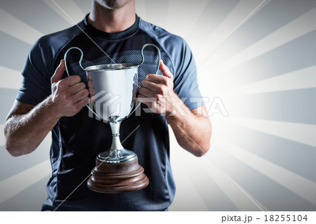 Composite image of victorious rugby player holding trophy 18255104