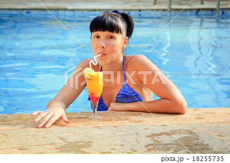 Young brunette drinking cocktail in the pool Young brunette drinking cocktail in the pool 18255735