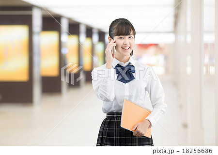 駅で待ち合わせをしている制服姿の女子高生の写真素材