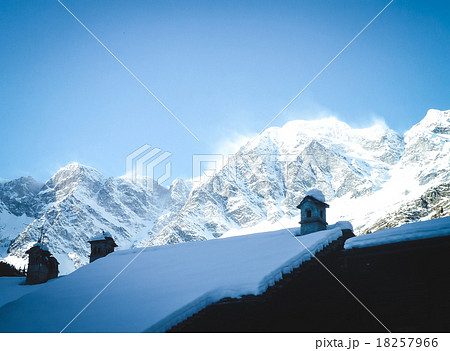 Snow-covered roof on a background of mountains 18257966