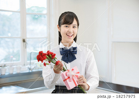 キッチンにプレゼントを持って立っている制服姿の女子高生 キッチンにプレゼントを持って立っている制服姿の女子高生 18257975