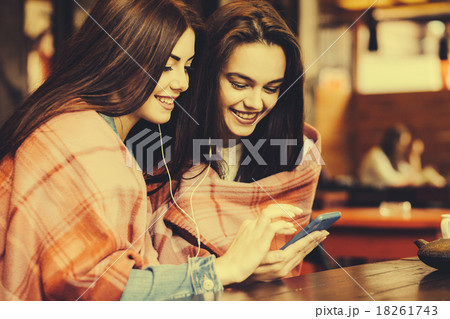 Two girl sitting listening to music 18261743