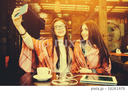 two close friends make selfie in the cafe 18261970