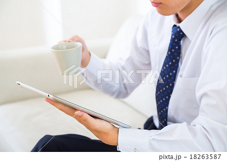 男性　ビジネスマン　朝　情報収集　タブレット端末　出勤前　手元　白背景　ホワイトバック　仕事　家 18263587