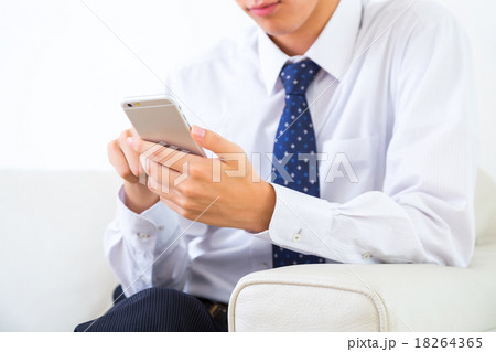 男性 ビジネスマン 携帯電話 手元 パーツモデル 携帯電話で検索 情報収集 白背景 ゲームの写真素材