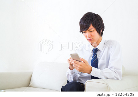 男性　ビジネスマン　携帯電話　手元　携帯電話で検索　情報収集　白背景　インターネット　FX　ゲーム 18264508