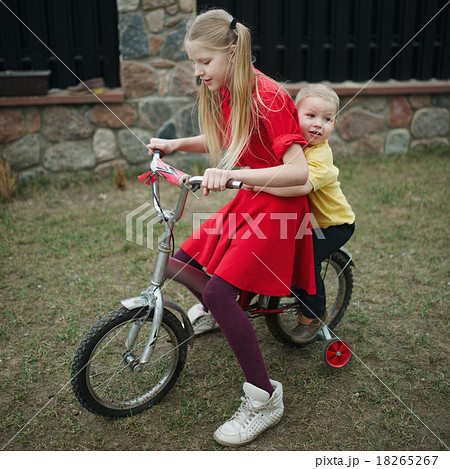 children ride on bicycle in yard children ride on bicycle in yard 18265267