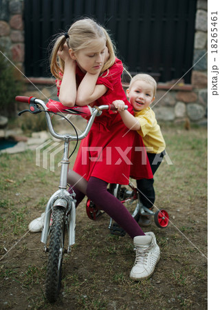children ride on bicycle in yard children ride on bicycle in yard 18265461