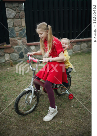 children ride on bicycle in yard 18265462