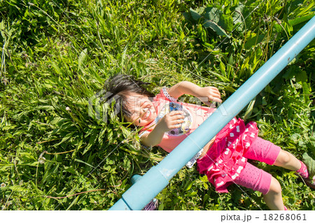 草むらで仰向けに寝る子供の写真素材