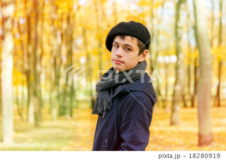Serious teenage boy in the autumn sunny park 18280919