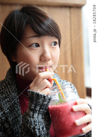 ジュースを飲む若い女性横目線 18285709