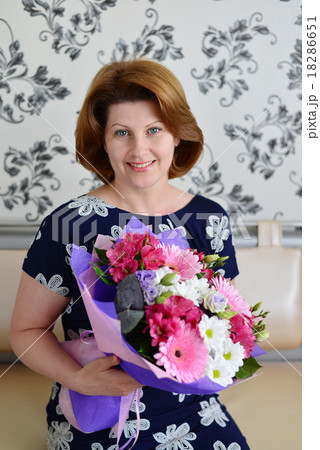 positive Woman with a bouquet of flowers in the room positive Woman with a bouquet of flowers in the room 18286651
