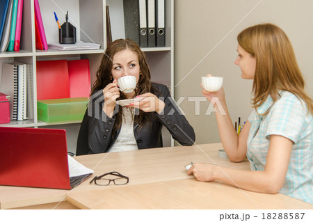 Two employees of the office talk and drink tea 18288587