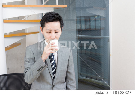 休憩中に紙コップで飲み物を飲むビジネスマンの写真素材 1087