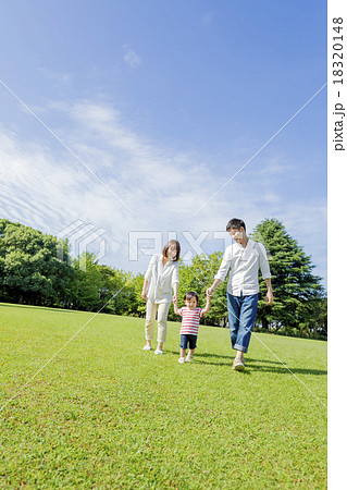 公園を手をつないで歩く3人家族 公園を手をつないで歩く3人家族 18320148
